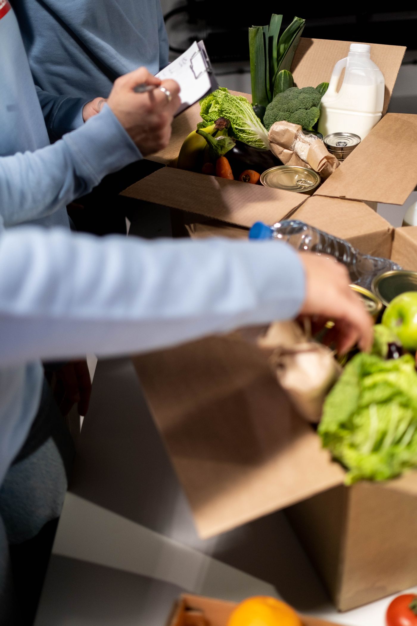 Volunteers sorting donated food into boxes